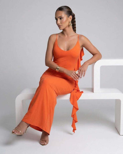 Model wearing the Celeste Maxi Dress by Lauven, featuring a bright orange spaghetti strap design and elegant silhouette.