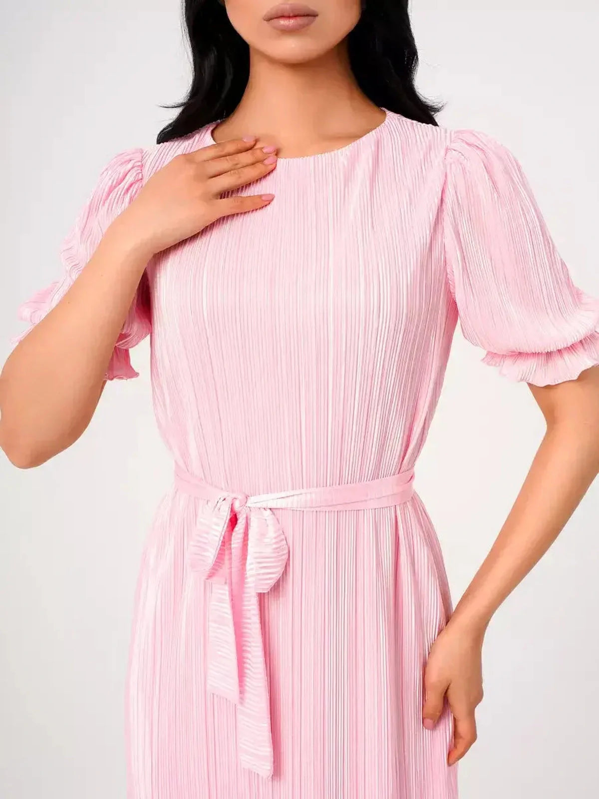 Model wearing the pink Celeste Maxi Dress featuring pleated fabric and puff sleeves with a tie waist.