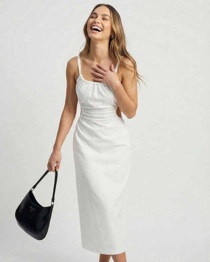 Celeste Midi Dress by Lauven showcasing a woman laughing in a white ruched dress with backless detail.