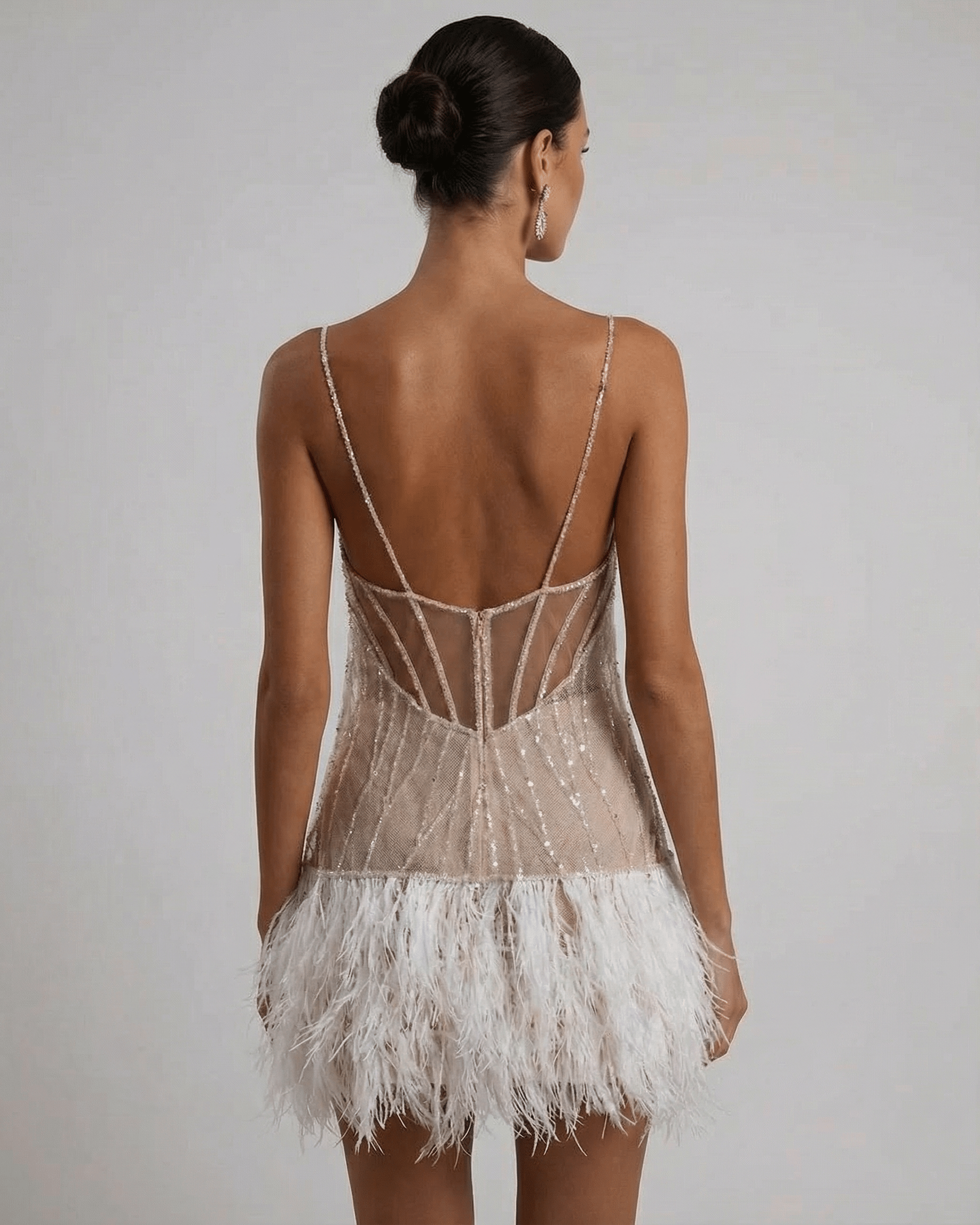 Celeste Mini Dress by Lauven, featuring a sequin tulle design and feather tassel hem, seen from the back.