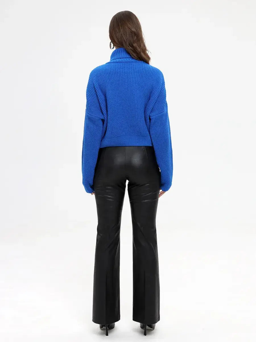 Back view of a model wearing the Lauven Celeste Sweater in vibrant blue with high-neck and flared pants.