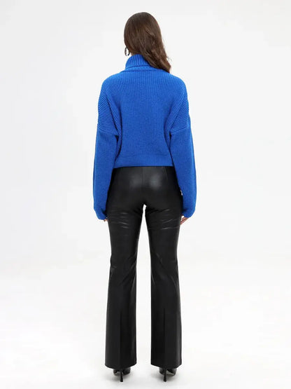 Back view of a model wearing the Lauven Celeste Sweater in vibrant blue with high-neck and flared pants.