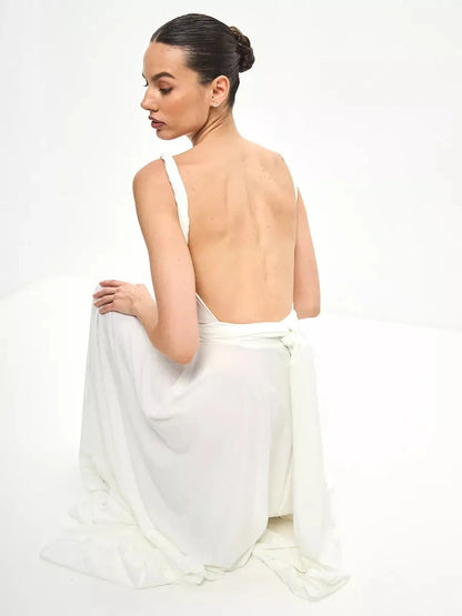Model showcasing the back view of the Celeste Wrap Maxi Dress in white, highlighting its elegant draped design.