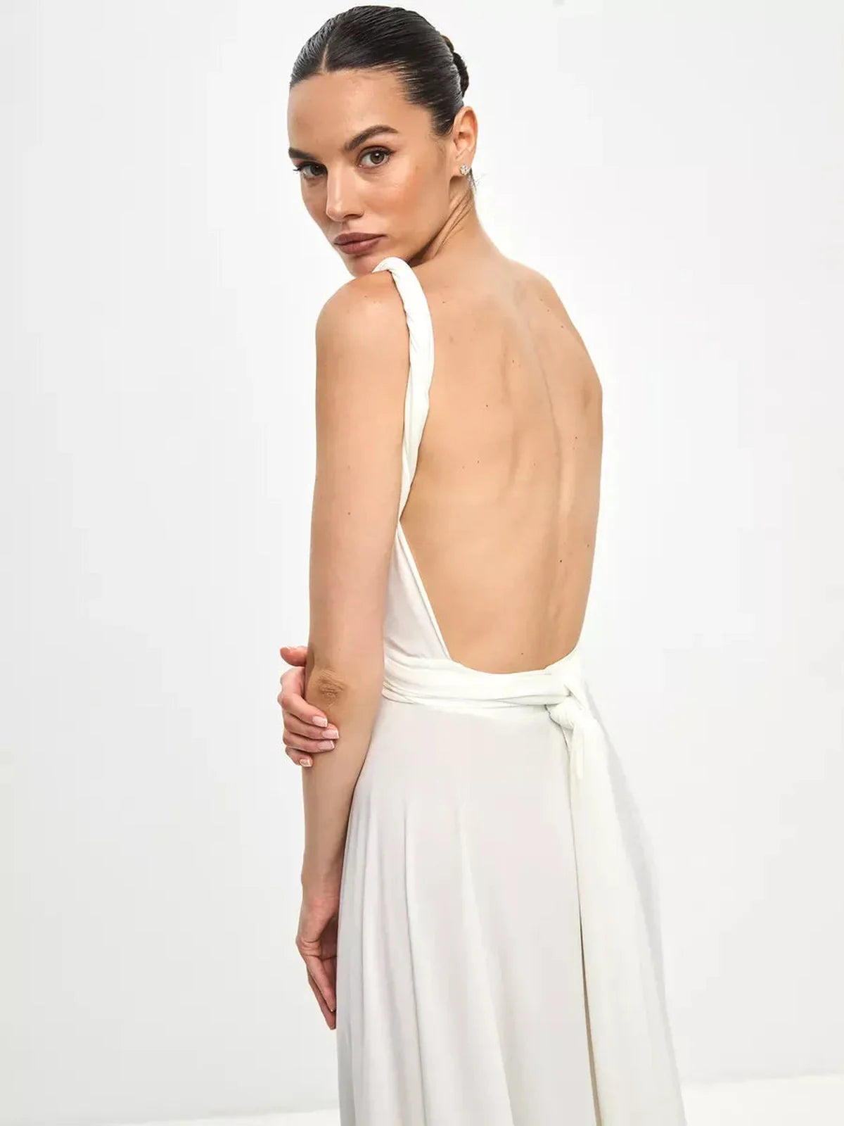 Model showcasing the back of the Celeste Wrap Maxi Dress with a plunging back and wrap tie detail.