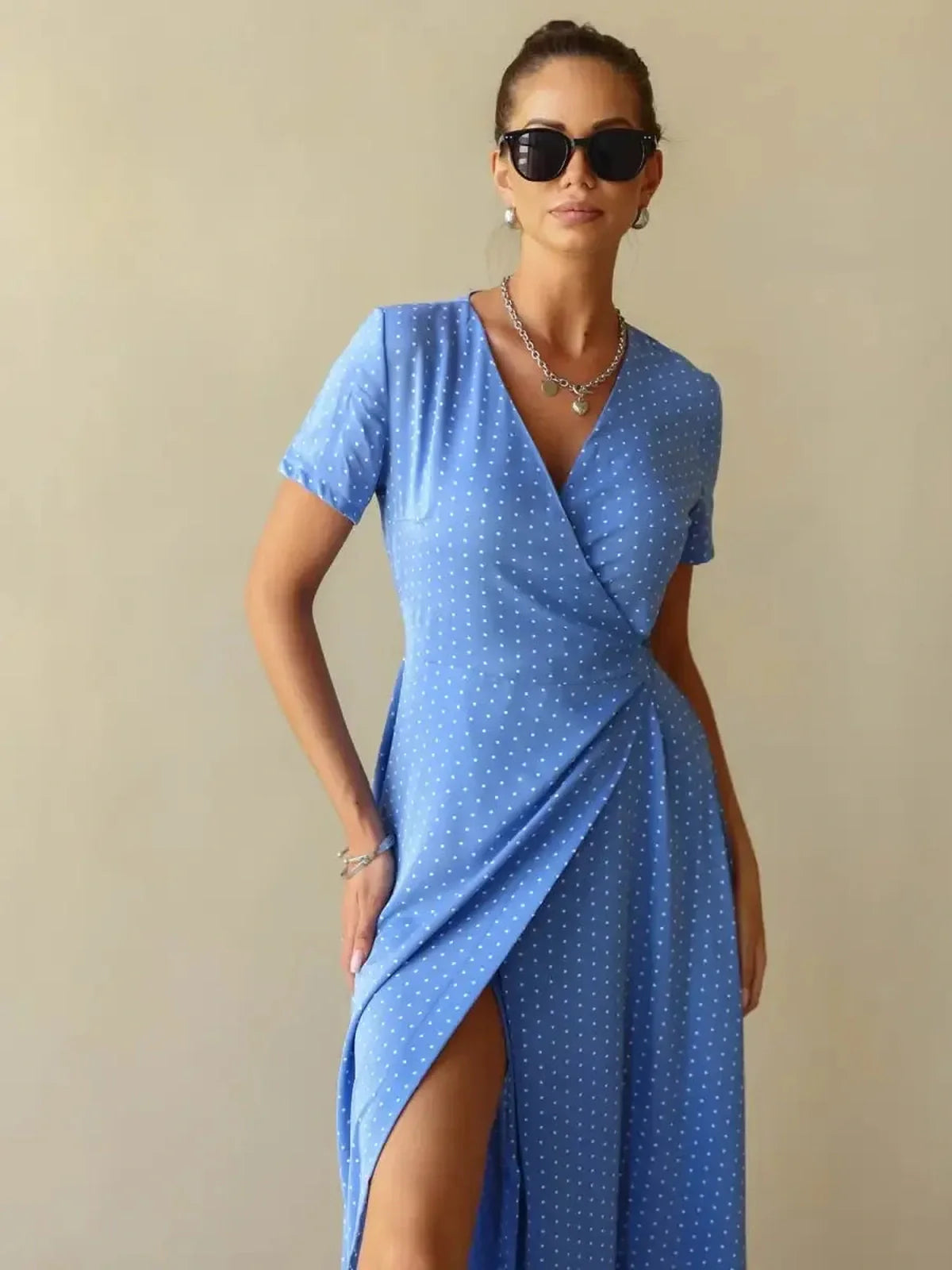 Celeste Wrap Maxi Dress in soft blue with polka dots, featuring a V-neck, wrap silhouette, and thigh-high slit.