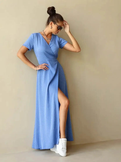 Celeste Wrap Maxi Dress in soft blue polka dot fabric featuring a flattering V-neckline and thigh-high slit.