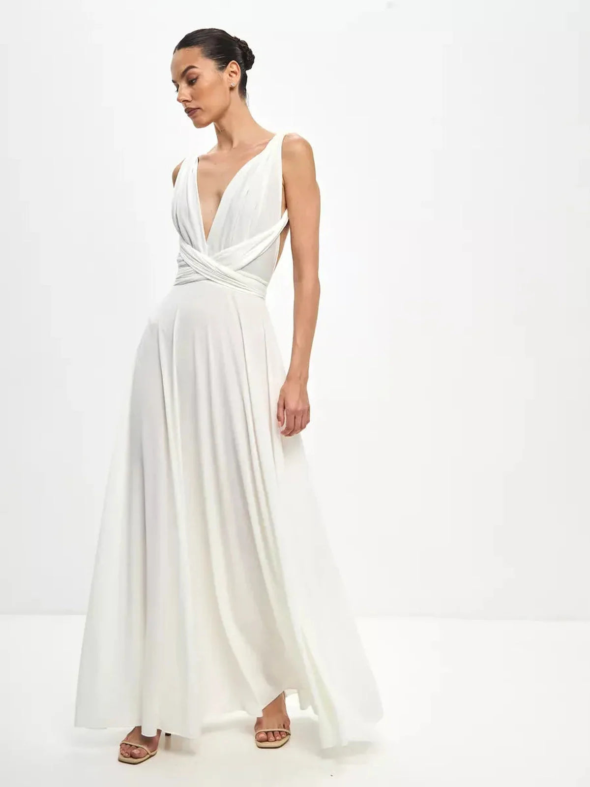 Model wearing the Celeste Wrap Maxi Dress with draped V-neck and convertible tie detail in a soft white hue.