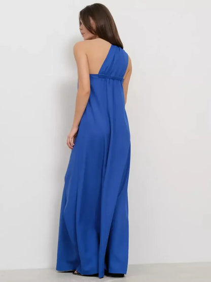Back view of a woman wearing a cerulean drape maxi dress, showcasing its elegant one-shoulder design and flowing silhouette.