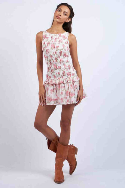 Model wearing a floral Chloe Mini Dress with a flared hem and cowboy boots, perfect for summer or casual outings.