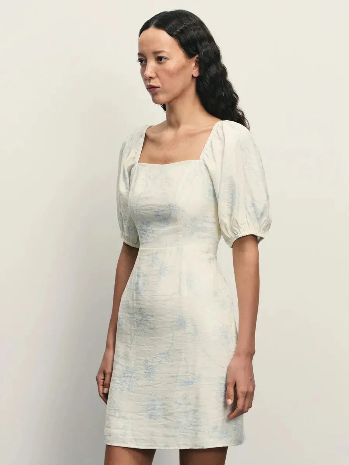 Elegant Cloud Bloom white mini dress with puff sleeves, square neckline, and pale blue floral pattern.