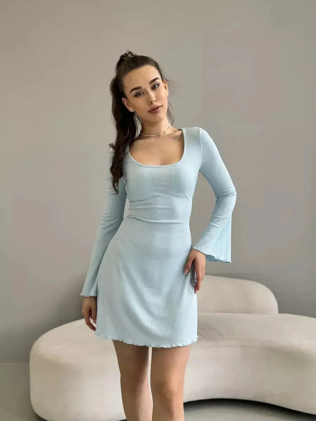 Model wearing a light blue Cloudline Charm mini dress with long bell sleeves, perfect for summer and weddings.