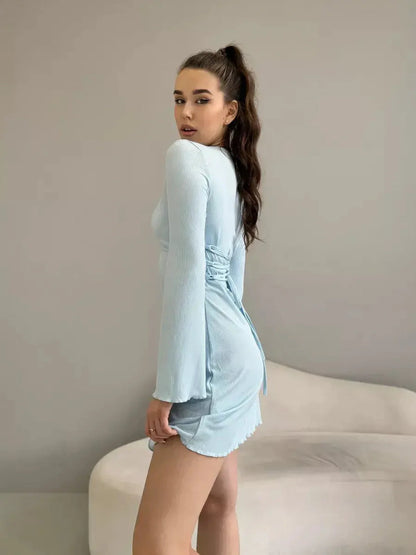 Model showcasing the elegant Cloudline Charm mini dress in soft blue with long bell sleeves and a flattering silhouette.