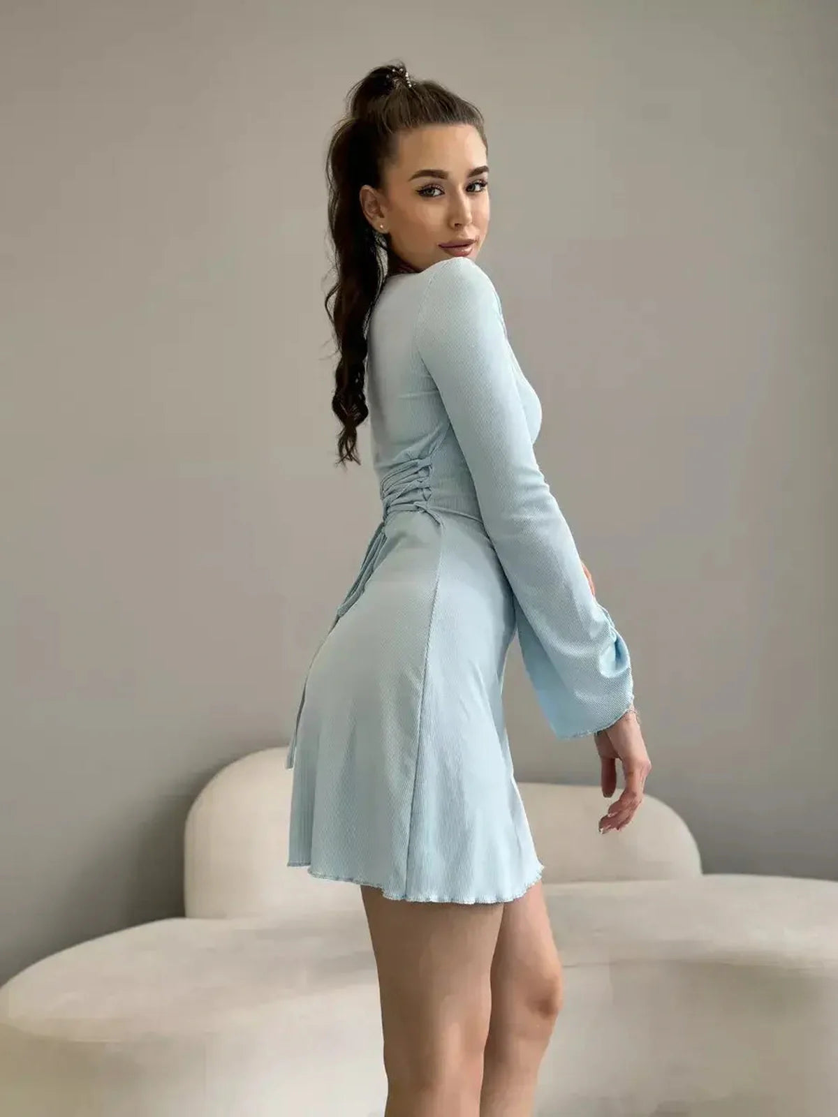 Model showcasing the dreamy Cloudline Charm mini dress in soft blue, perfect for summer parties and weddings.