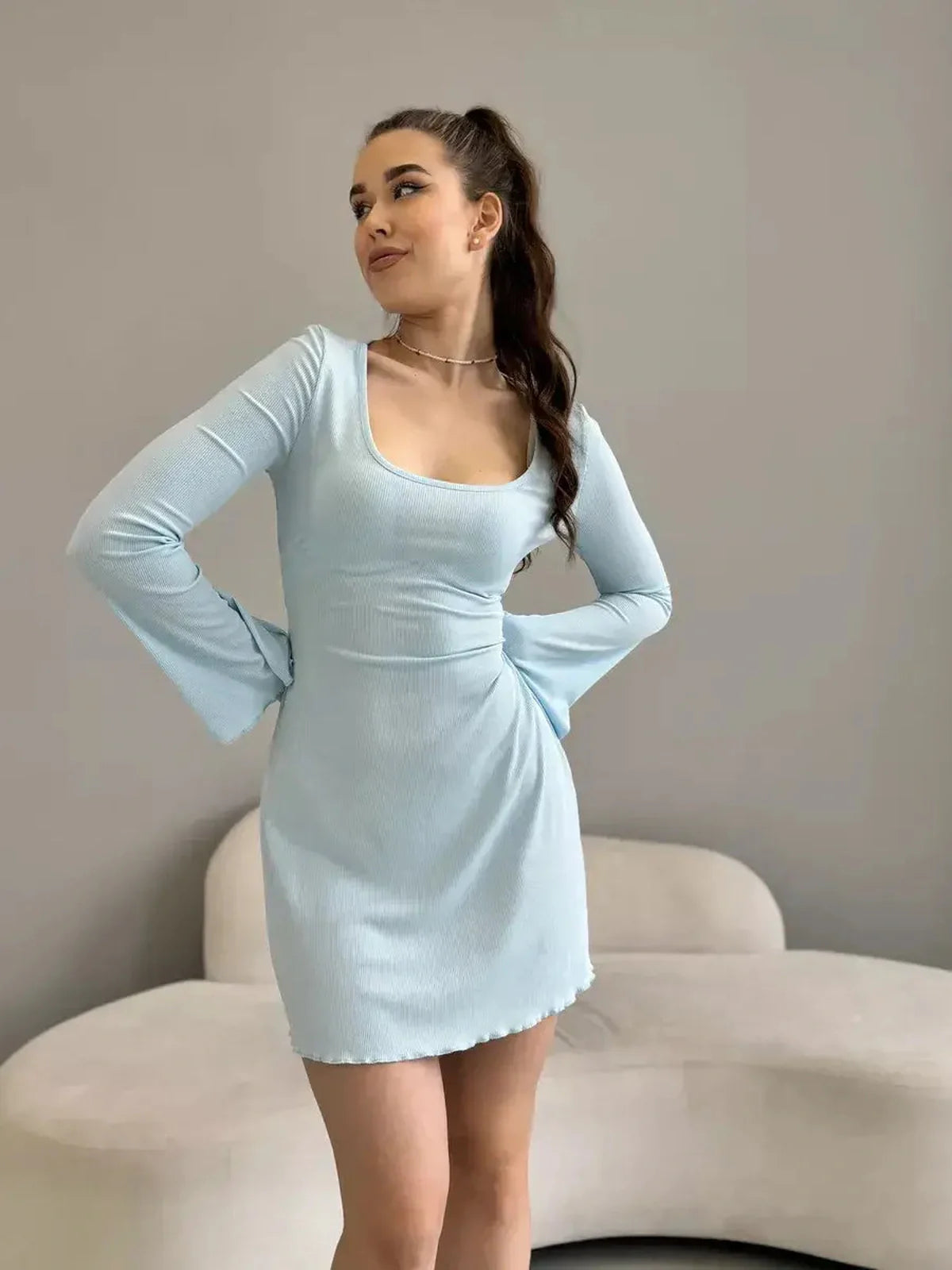 Model wearing the Cloudline Charm mini dress in light blue, showcasing its flattering silhouette and bell sleeves.