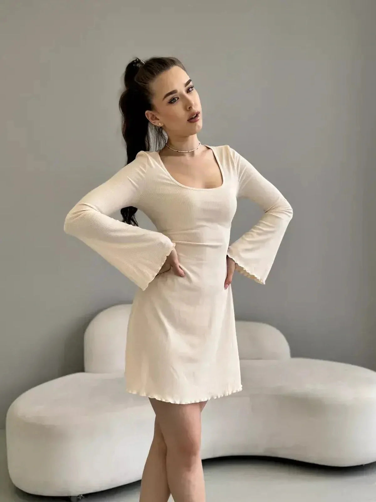Fitted long sleeve Cream Belle mini dress in creamy white, perfect for weddings or casual gatherings, featuring a square neckline.