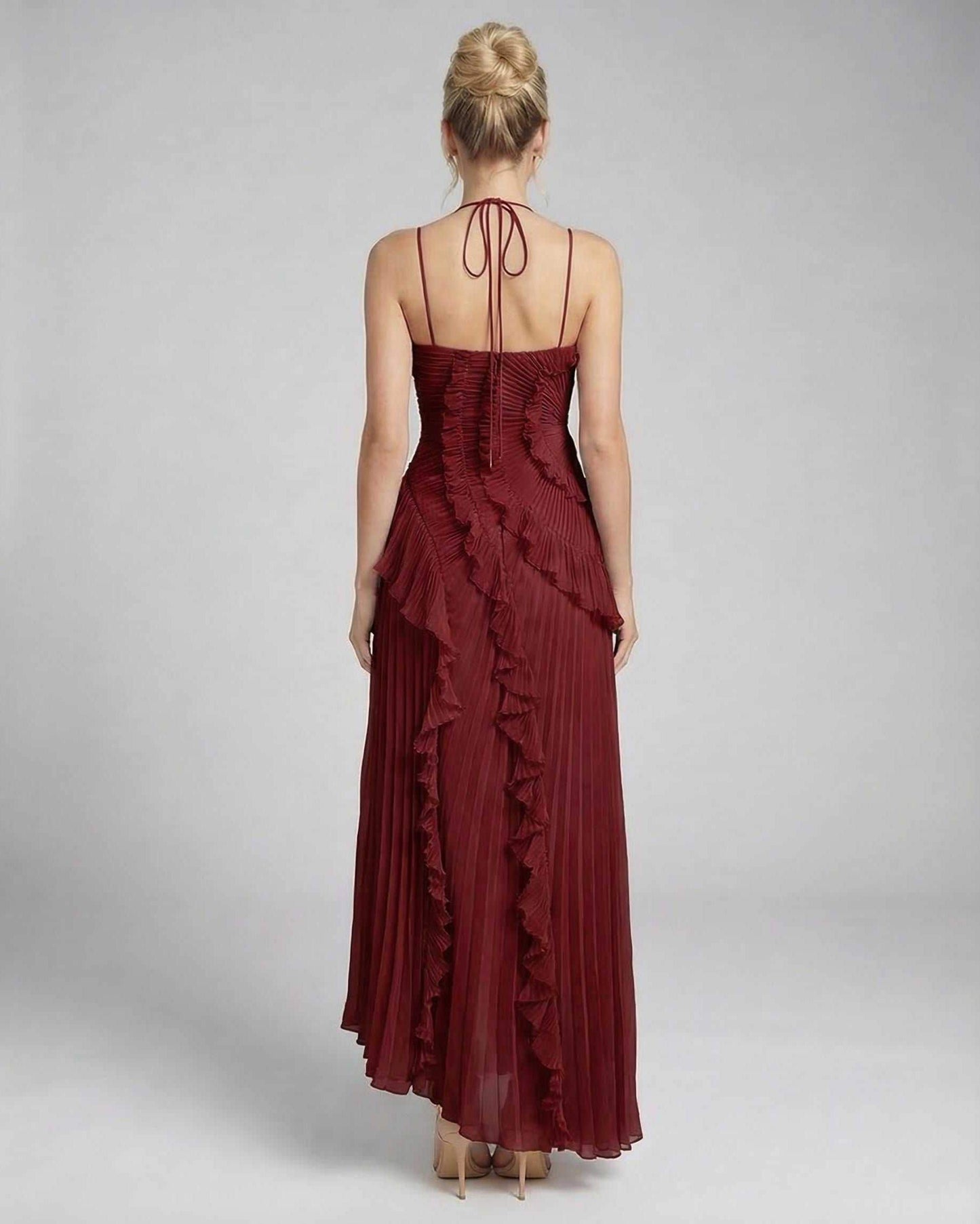 Back view of a model wearing the Lauven Crimson Maxi Dress, showcasing its pleated chiffon and ruffle details.