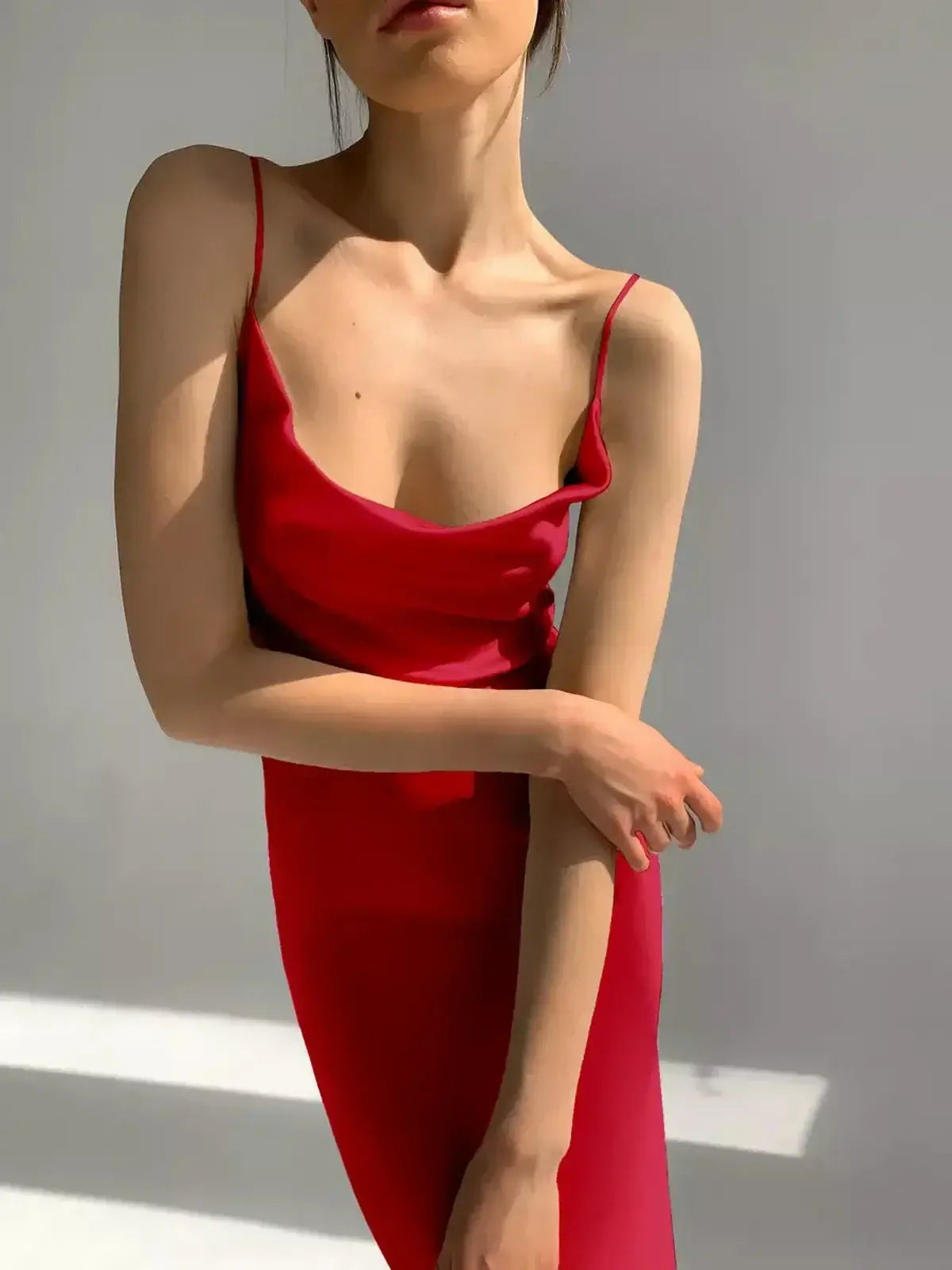 Elegant model showcasing the Crimson Muse Midi Dress, a sleek satin piece in vibrant red.