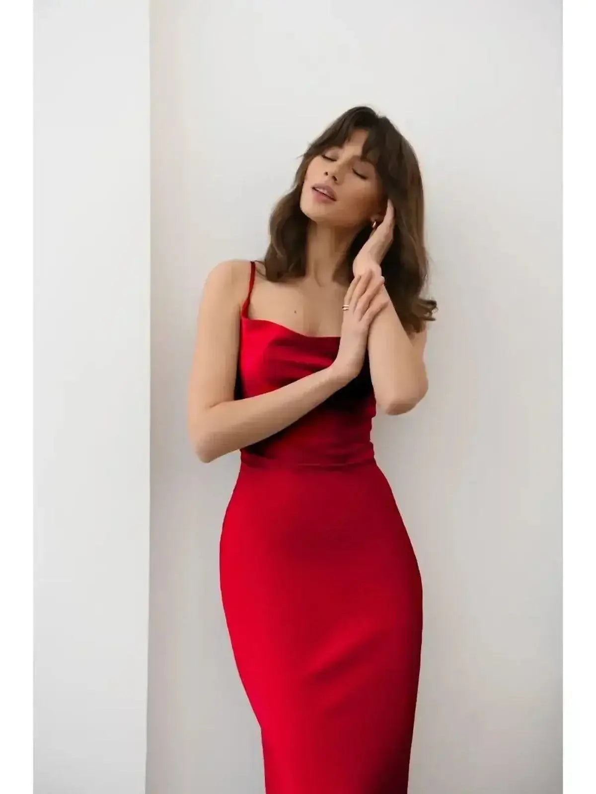 Model showcasing the sleek and sultry Crimson Muse Midi Dress in vibrant red satin against a minimalist background.