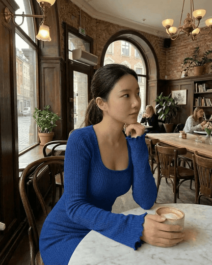 Model wearing the Crimsona Maxi Dress in blue, enjoying coffee at a café, highlighting its elegant design.
