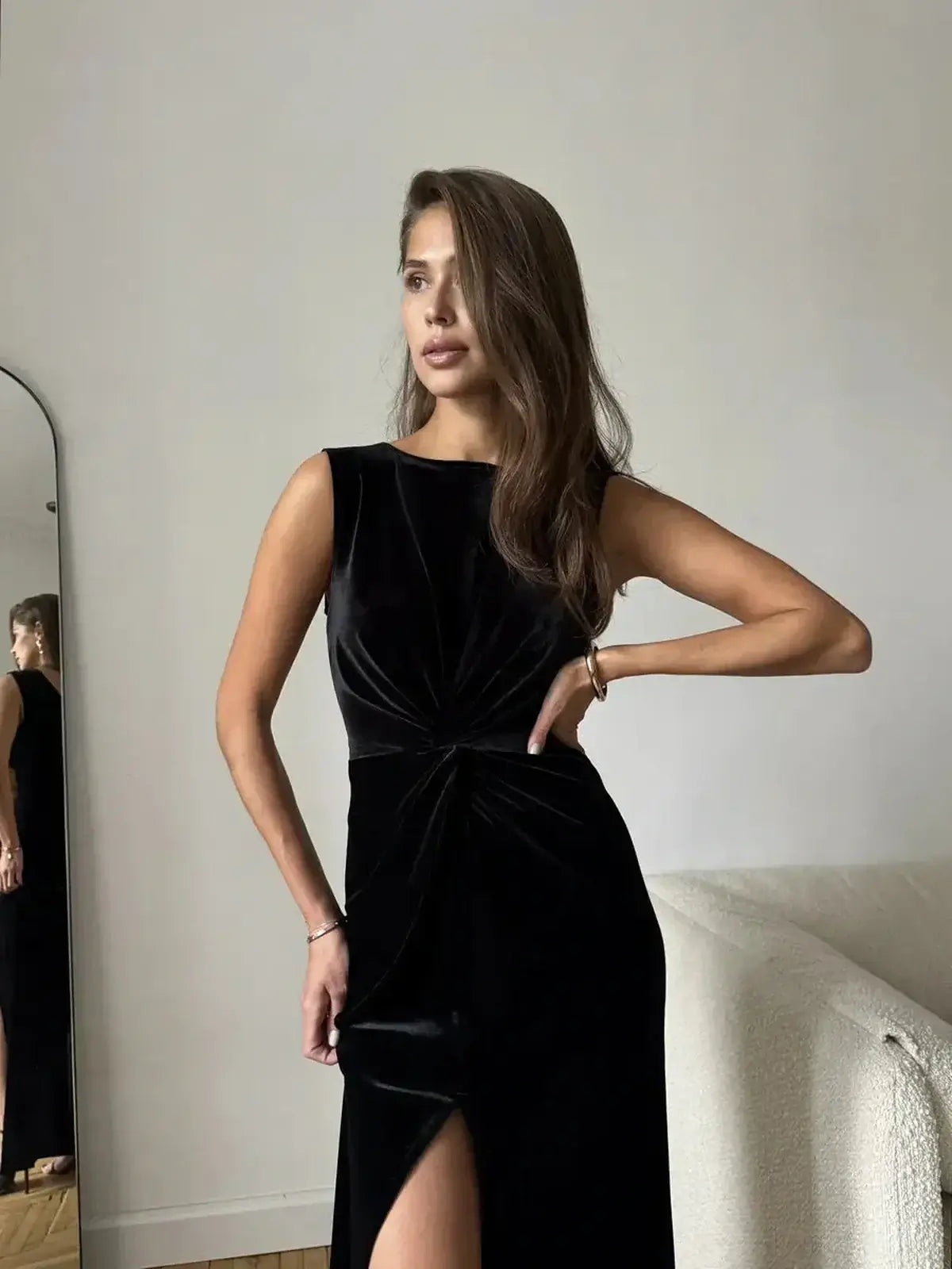 Model wearing the Eclipse Maxi Dress in black velvet, featuring a draped knot detail and thigh-high slit, ideal for formal occasions.