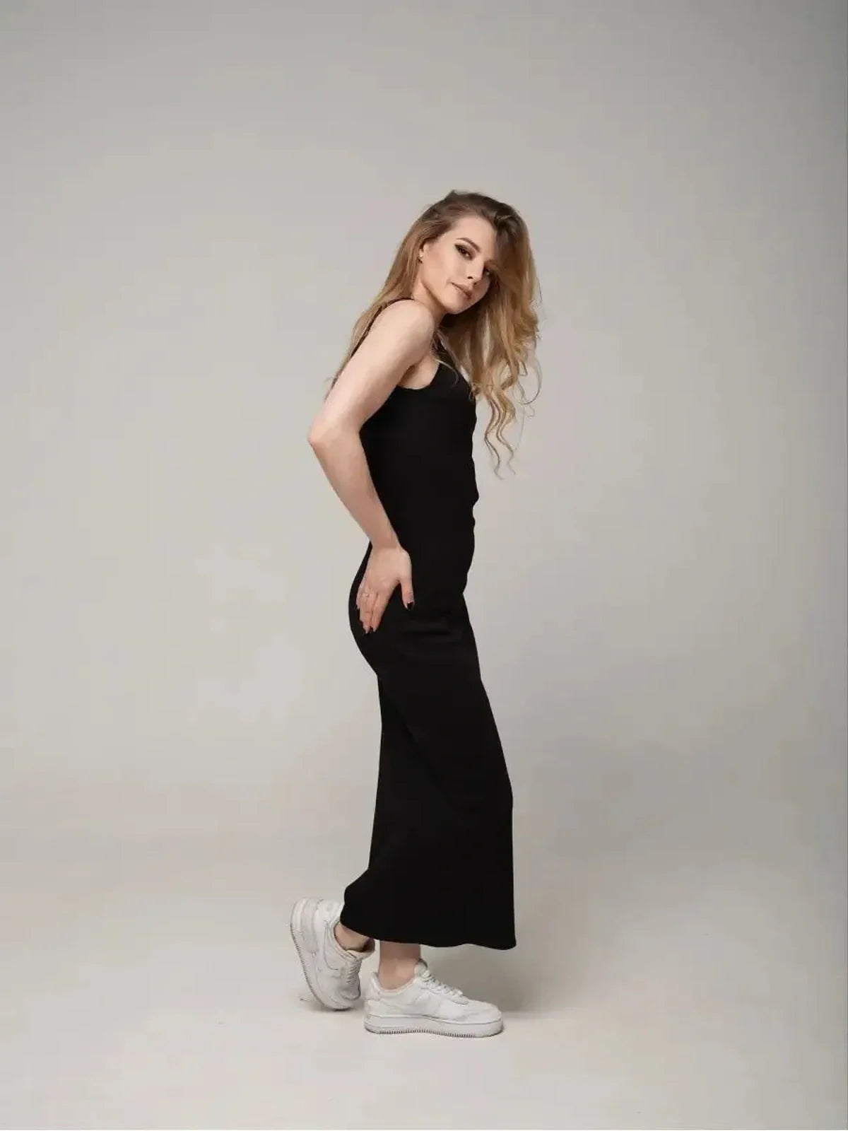 Eclipse Maxi Dress on model, showcasing minimalist elegance with a sleeveless design and stylish white sneakers.