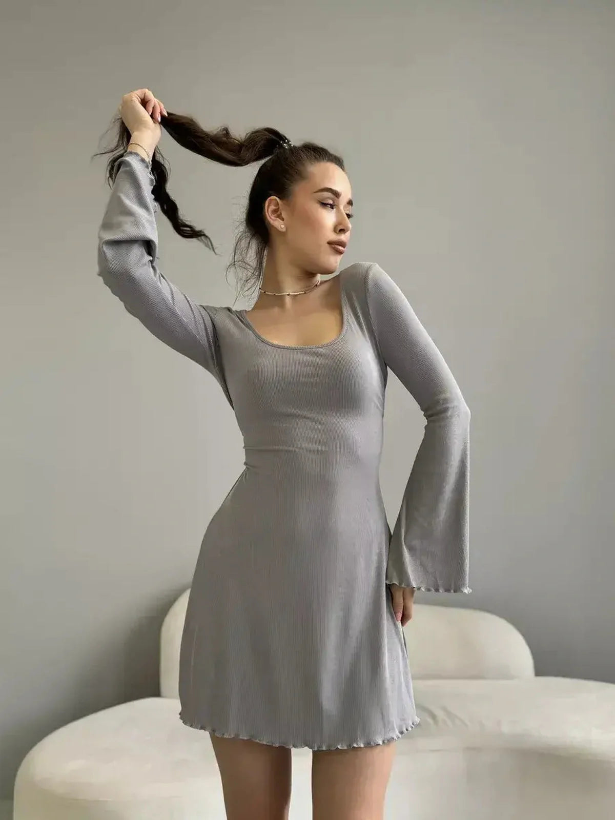 Model showcasing the Silver Flare light gray mini dress with flared sleeves and a sculpted fit, perfect for summer occasions.