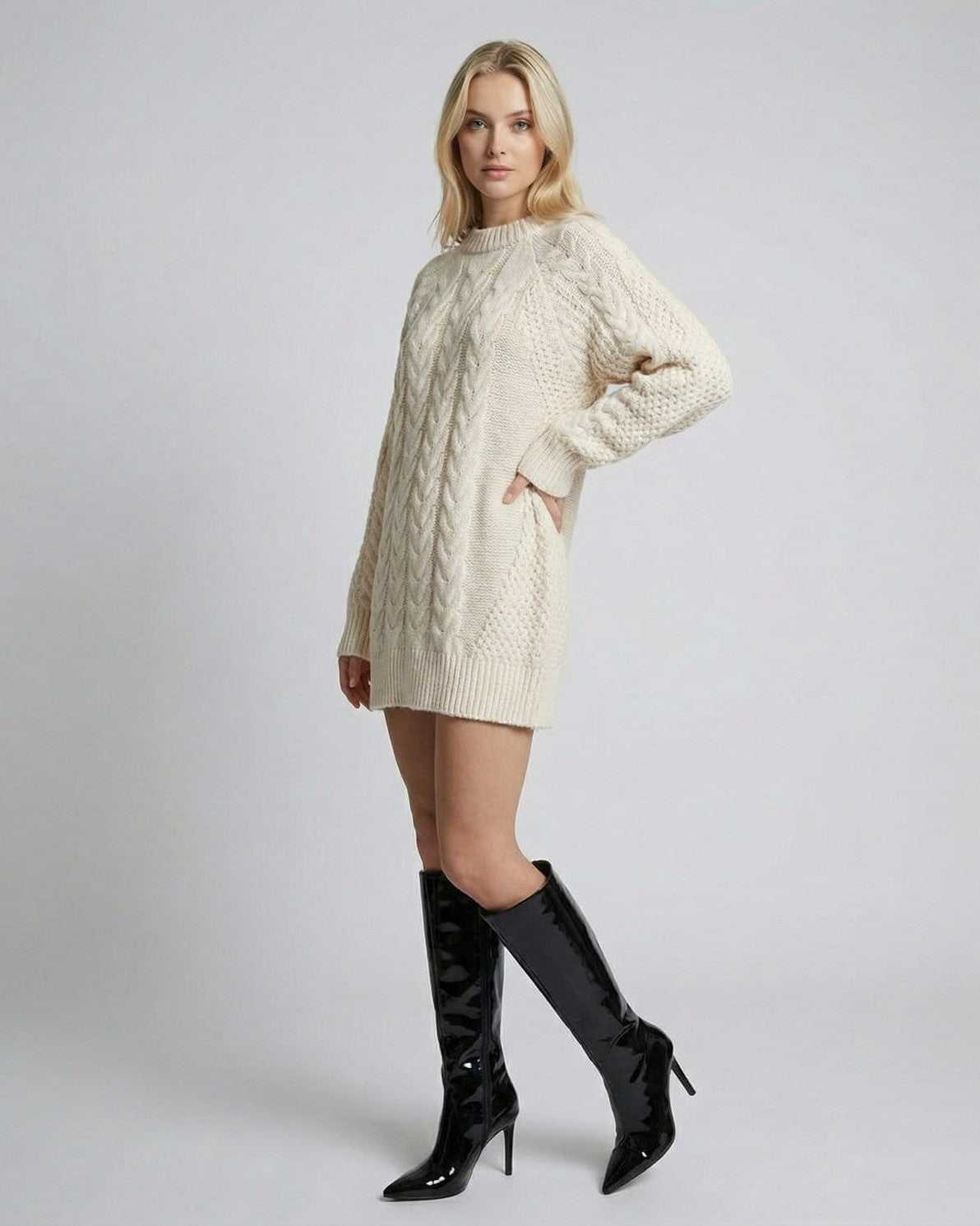 Eira Sweater by Lauven, showcasing minimal cable-knit design, worn with stylish over-the-knee boots in a neutral setting.
