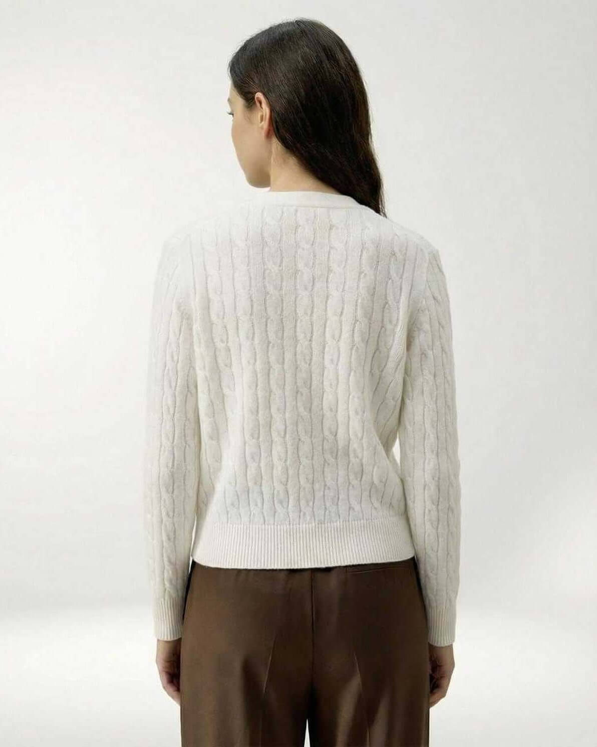 Back view of woman wearing the Lauven Elara Cardigan, a white classic cable knit sweater.