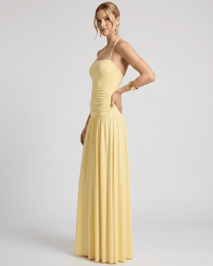 Elara Maxi Dress in yellow stretch jersey, halter neck design, featuring a ruched waist and flowing skirt for effortless elegance.