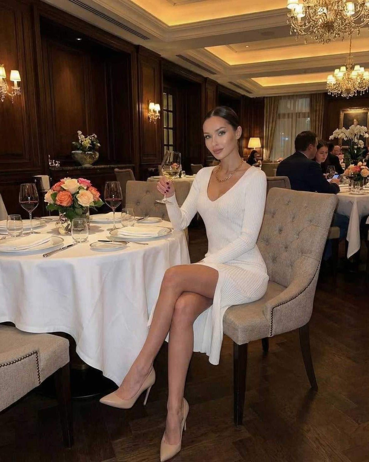 Elara Midi Dress by Lauven, elegant white ribbed knit V-neck pencil dress in a stylish dining setting.