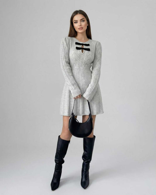 Elara Mini Dress by Lauven featuring a long sleeve knit design with bow detail, styled with a black bag and knee-high boots.