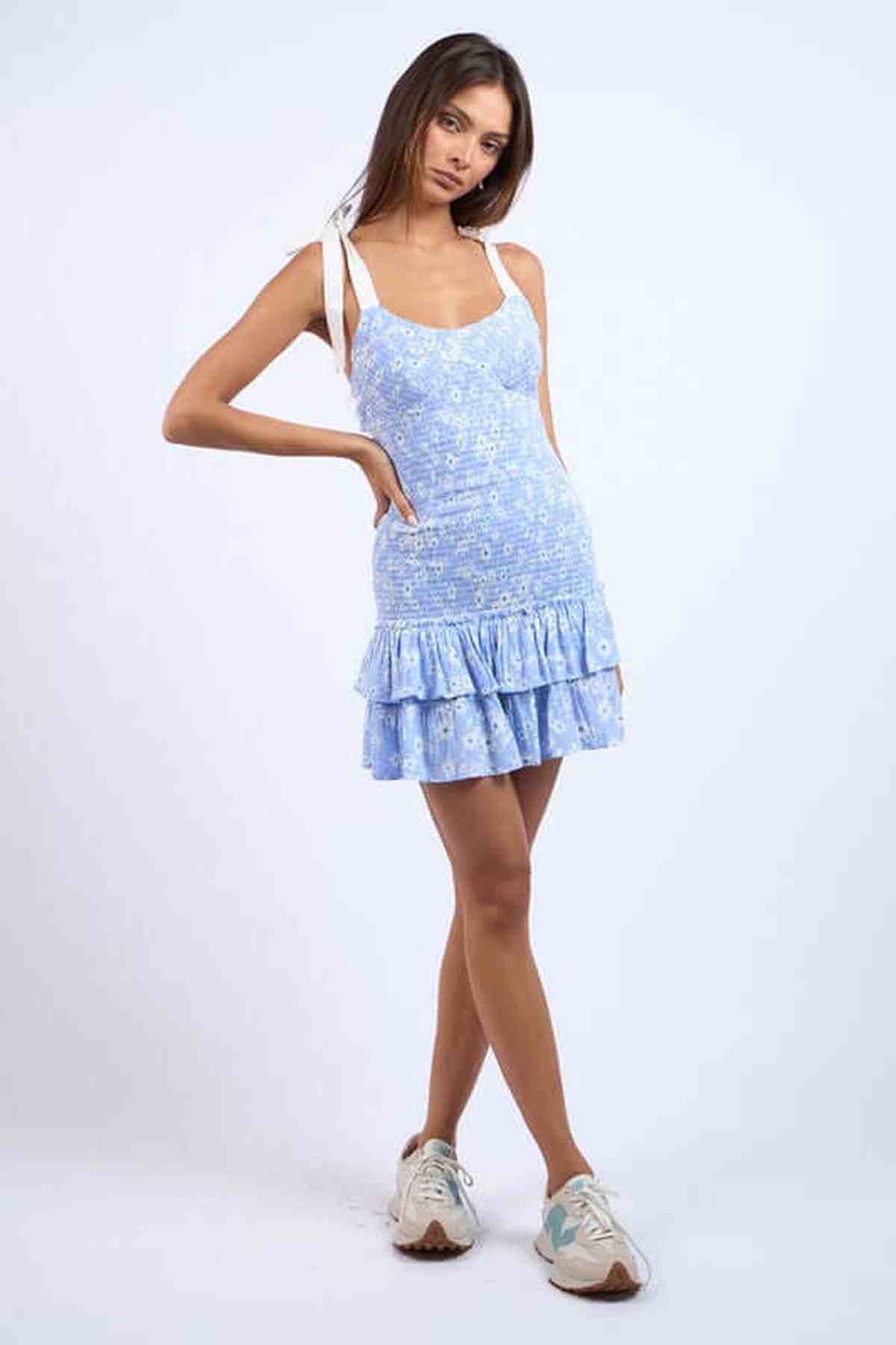 Model showcasing the Elise Mini Dress with a floral print and ruffled hem, perfect for summer and casual outings.