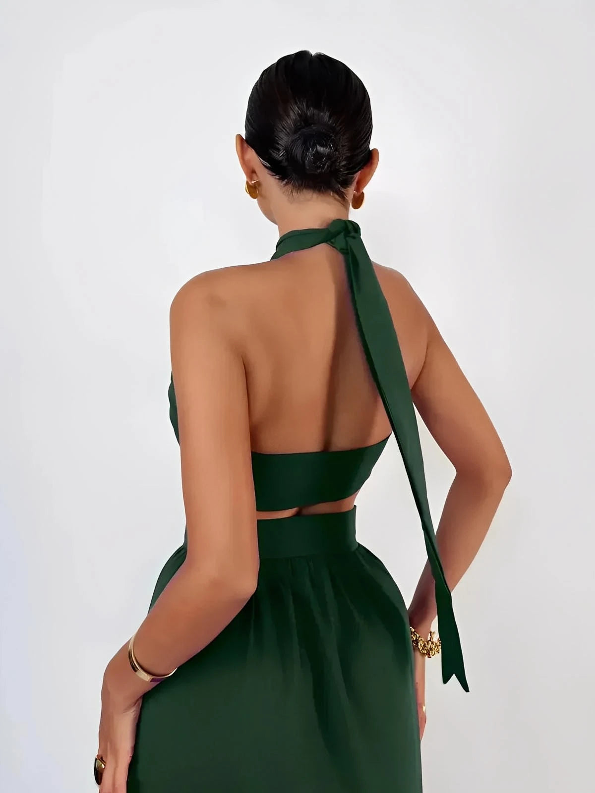 Elegant woman in a deep green halter crop top from the Emerald Muse Set, showcasing a chic back design.