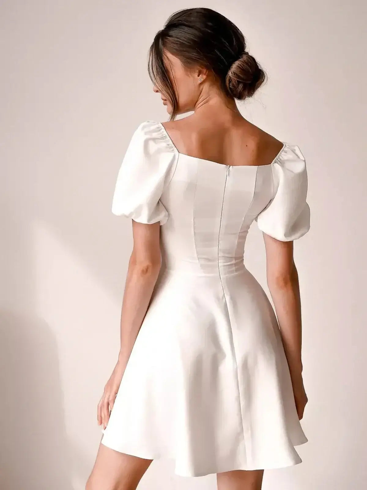 Ethereal Belle white mini dress with puff sleeves and a square neckline, perfect for wedding guests or summer parties.