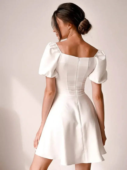 Ethereal Belle white mini dress with puff sleeves and a square neckline, perfect for wedding guests or summer parties.