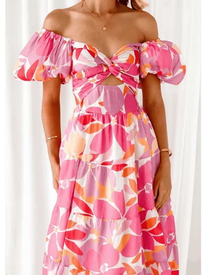 Flora Muse Maxi Dress featuring vibrant pink, orange, and coral floral prints with an off-shoulder style and puff sleeves.
