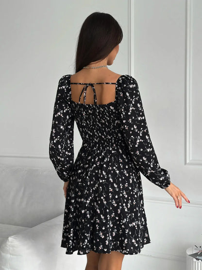 Flora Noir black mini dress with floral print, fitted waist, and long sleeves, perfect for weddings and cocktail events.