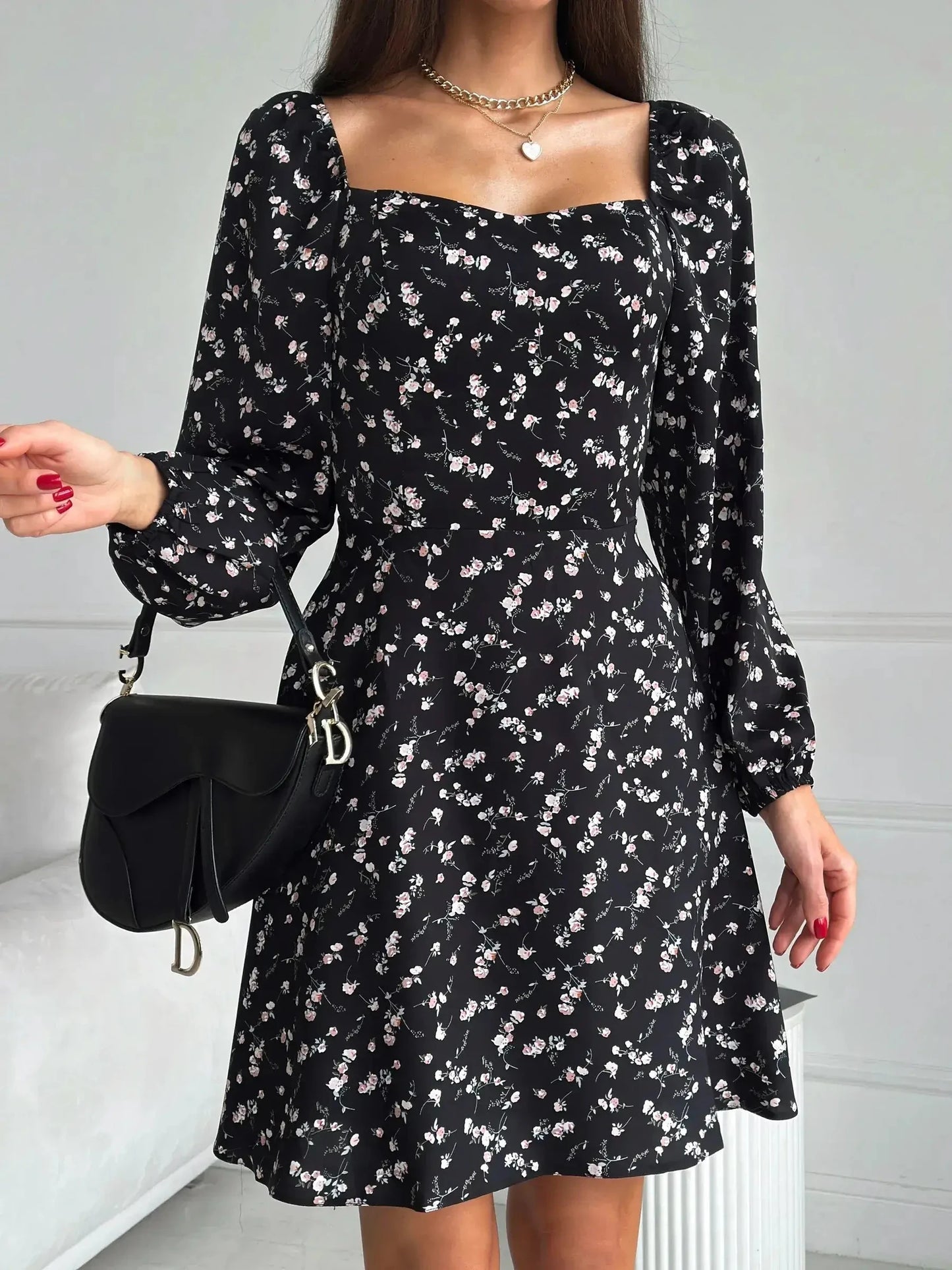 Flora Noir mini dress featuring a floral print, fitted waist, flared skirt, and long sleeves, ideal for summer events.