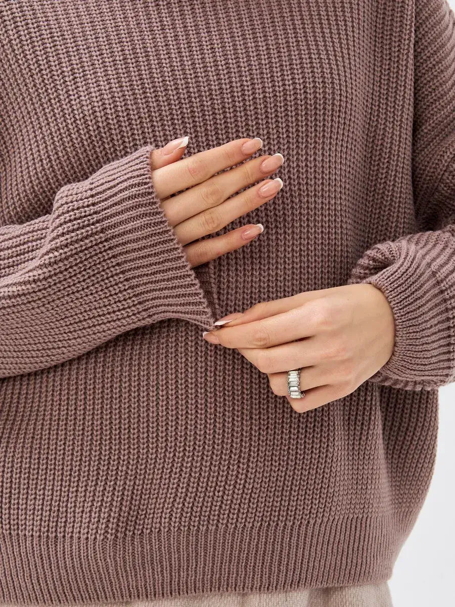 Close-up of hands adjusting the sleeve of the Florence Sweater by Lauven, showcasing its textured knit design.
