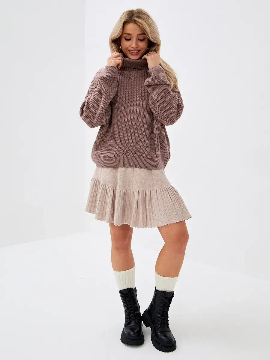 Florence Sweater by Lauven, oversized knit with turtleneck, worn with pleated skirt for a stylish look.