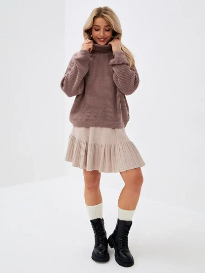 Florence Sweater by Lauven, oversized knit with turtleneck, worn with pleated skirt for a stylish look.