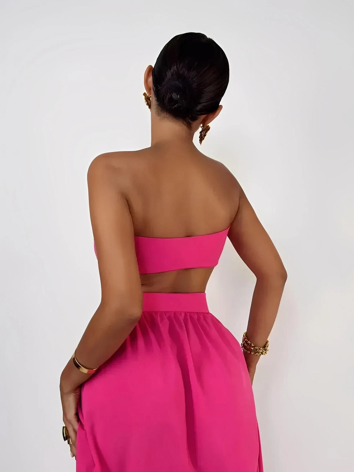 Model wearing a Fuchsia Breeze Set, showcasing the criss-cross top and flowing skirt from the back.
