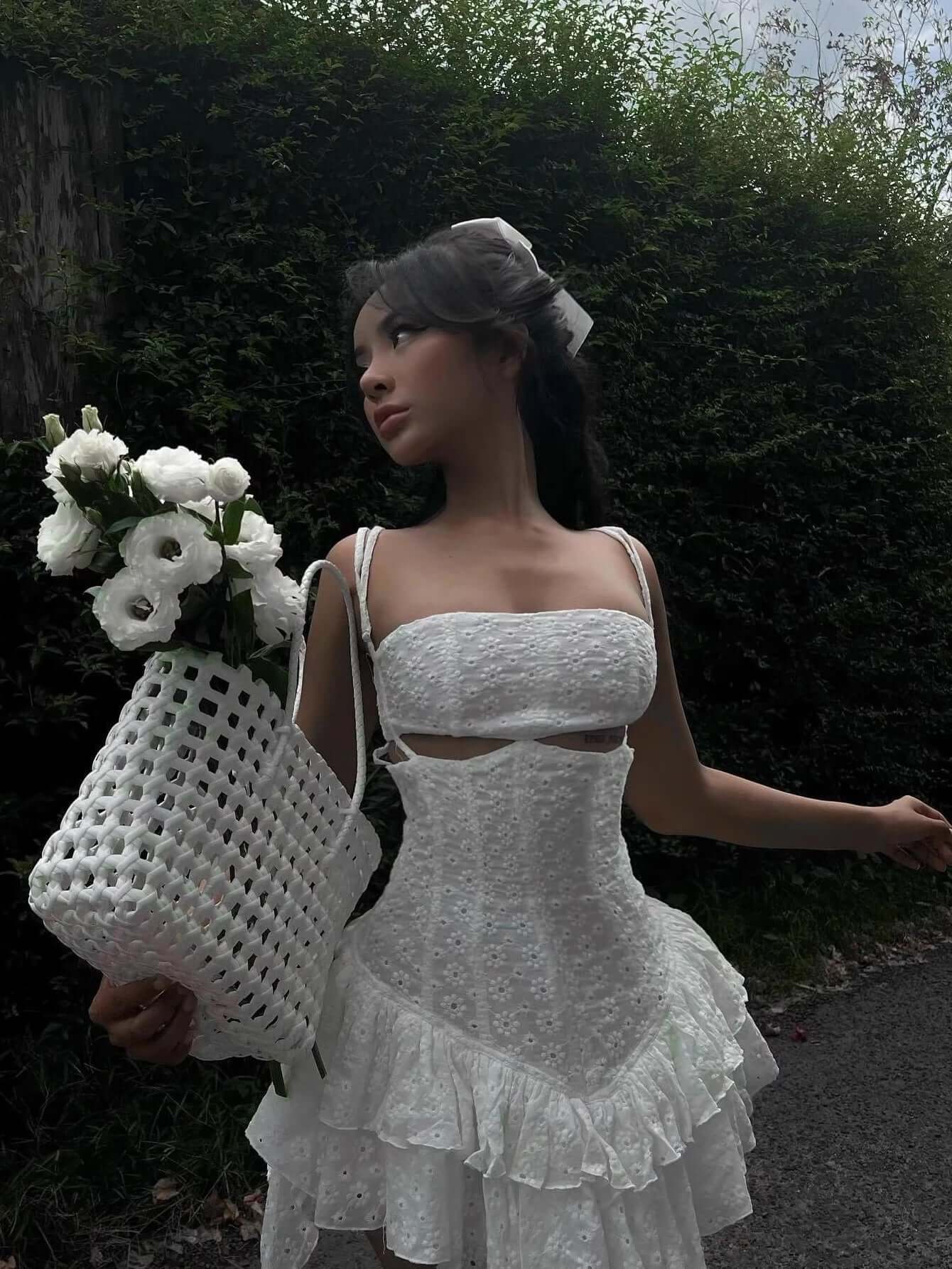 Elegant white mini dress with lace detail, perfect for weddings or special occasions, paired with a stylish basket and flowers.