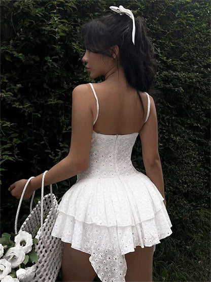 Back view of a woman in a white mini dress with lace detail, perfect for summer weddings and special occasions.