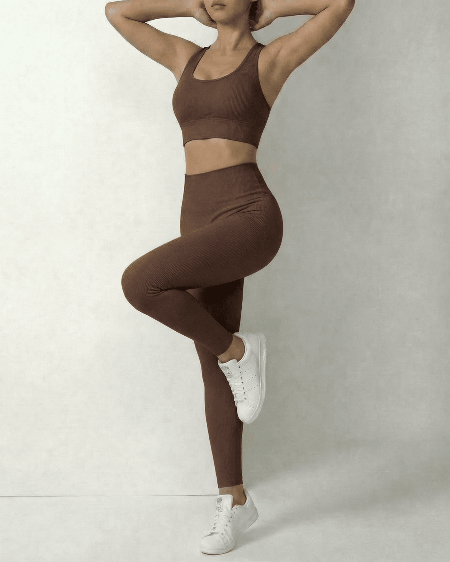 Model wearing Hazel Leggings by Lauven, showcasing sleek brown high-waist design and sporty style.
