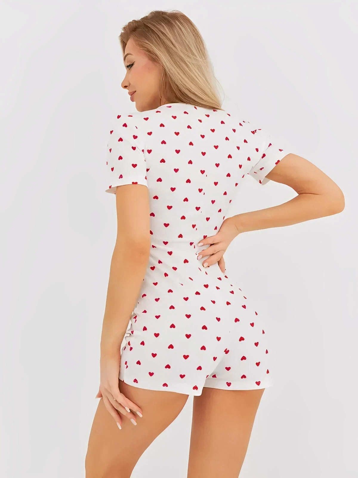 Woman in a heart print V-neck romper showcasing a playful and chic style, perfect for casual wear.