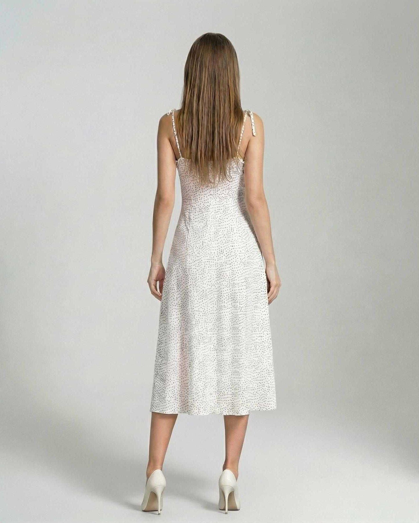 Back view of a woman wearing the Elara Midi Dress by Lauven, showcasing its elegant A-line silhouette and polka dot detail.