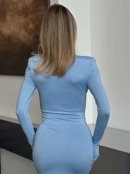 Back view of a woman wearing the Azure Flame Maxi Dress in a soft blue hue, showcasing its sculpting design.
