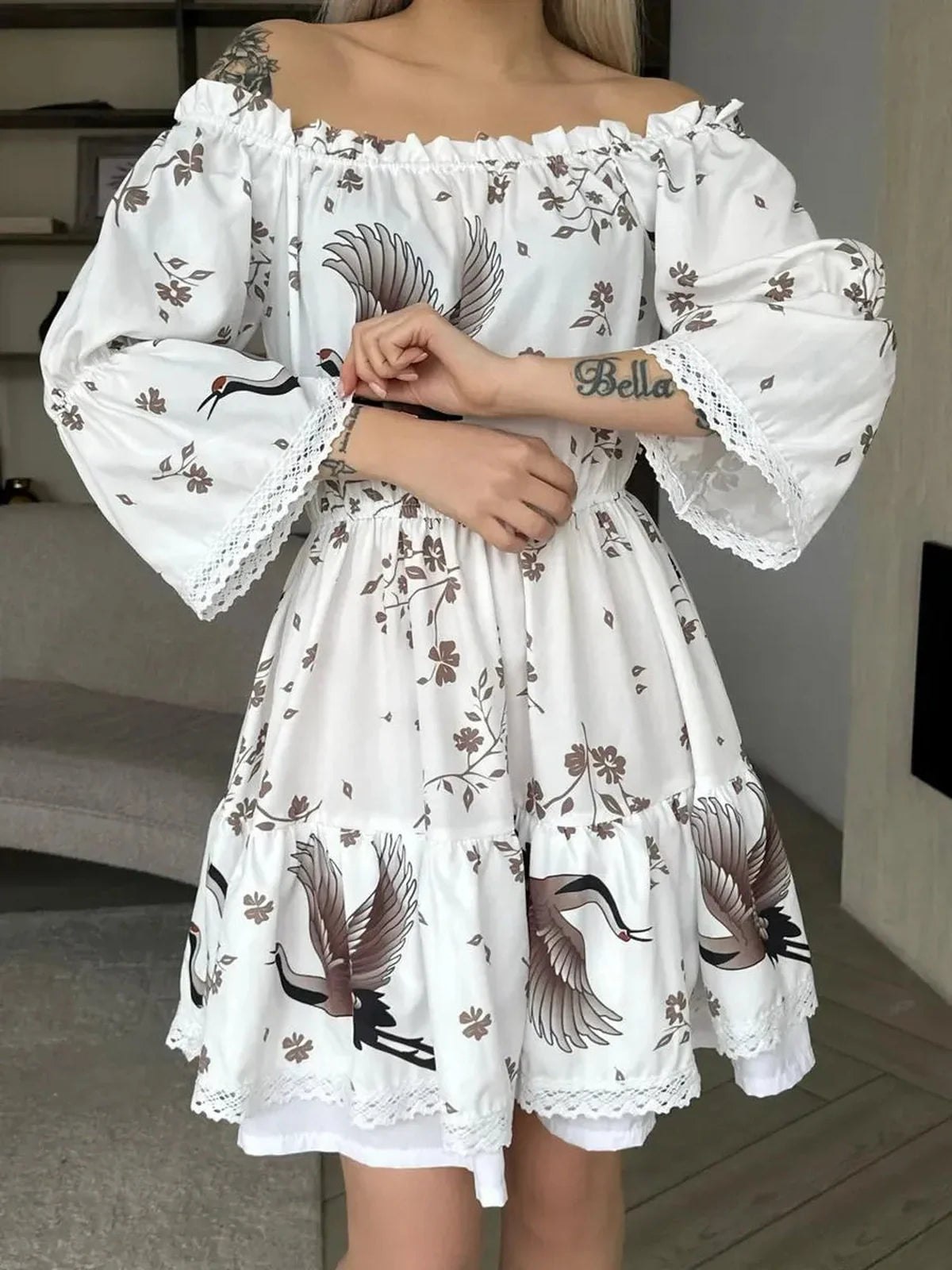 Elegant White Crane summer dress with floral and crane motifs, showcasing off-the-shoulder design and flowing silhouette.