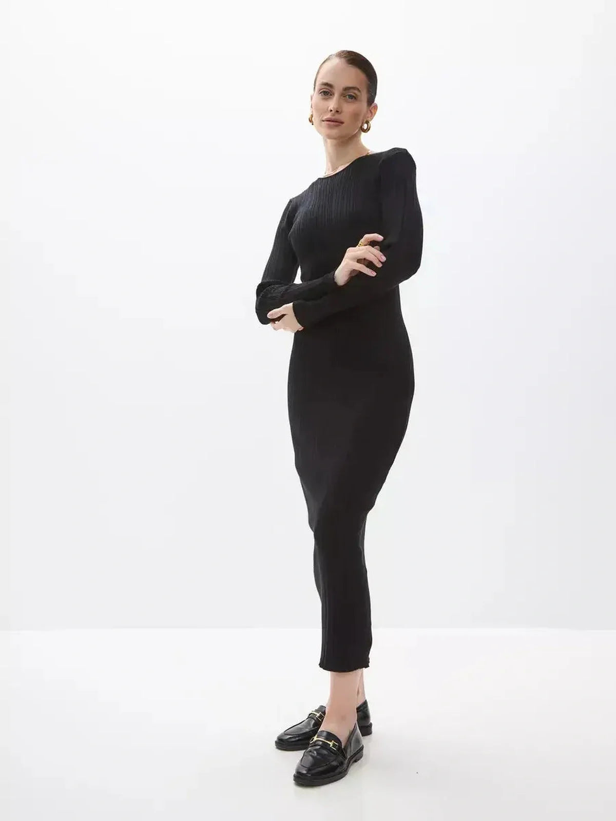 Model wearing a Sculpted Rib Maxi Dress in black, showcasing its body-skimming fit and elegant design.